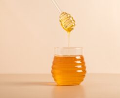 Honey,In,A,Transparent,Jar.,A,Honey,Spoon,Is,Dipped